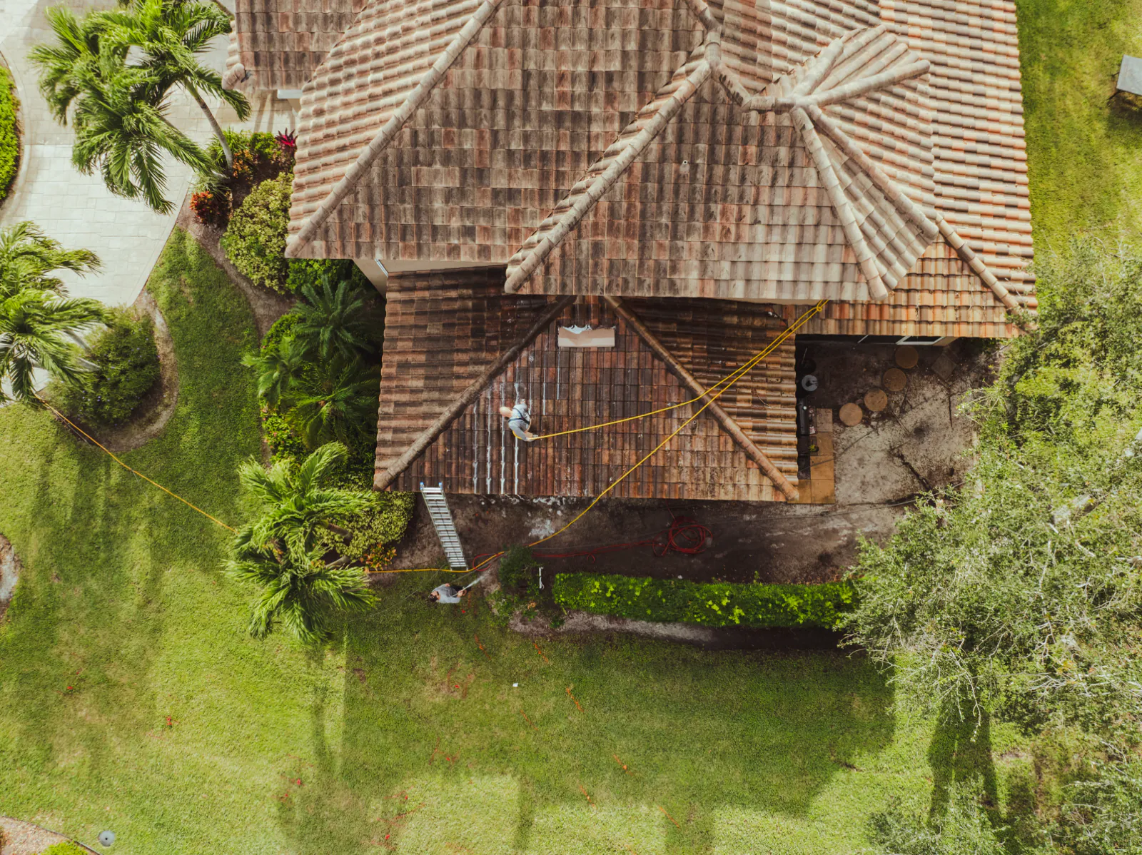 Top-down drone view of the tile roof before cleaning, dark with algae