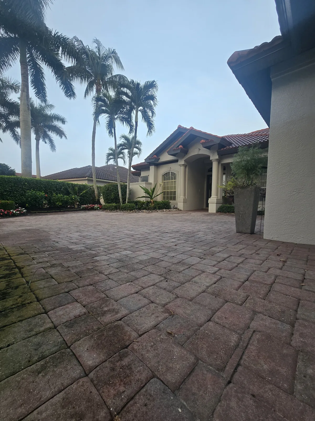 Driveway pavers with failed, peeling sealer before the project