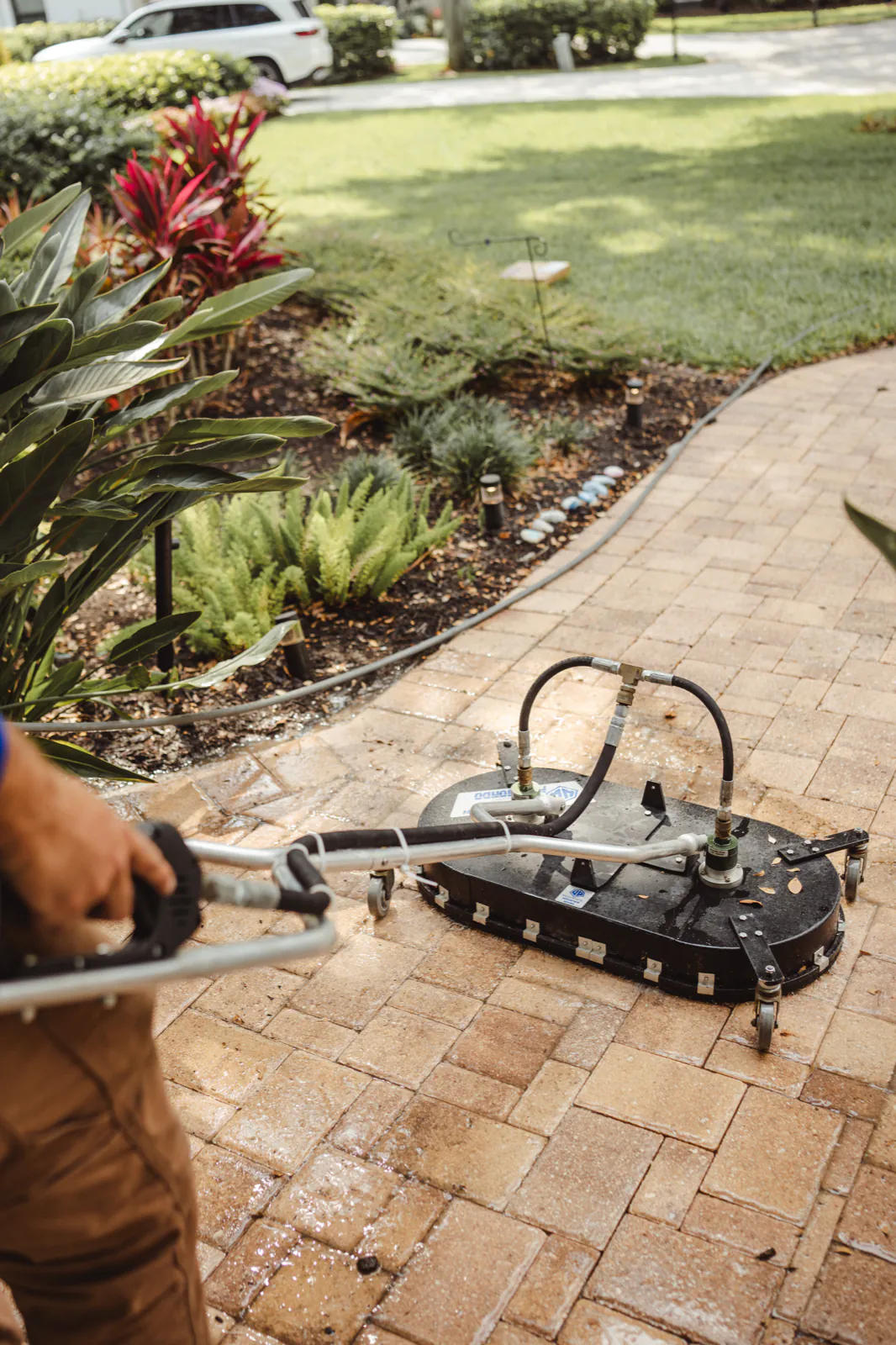 Cleaning the curved paver walkway with a rotary surface cleaner