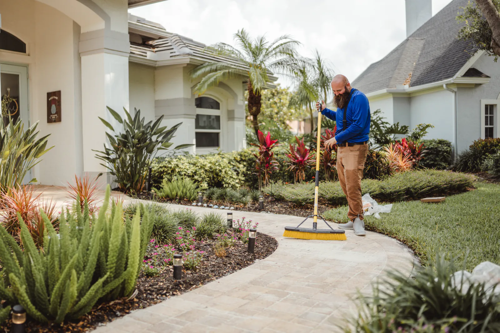 Sweeping polymeric sand into the walkway joints before sealing